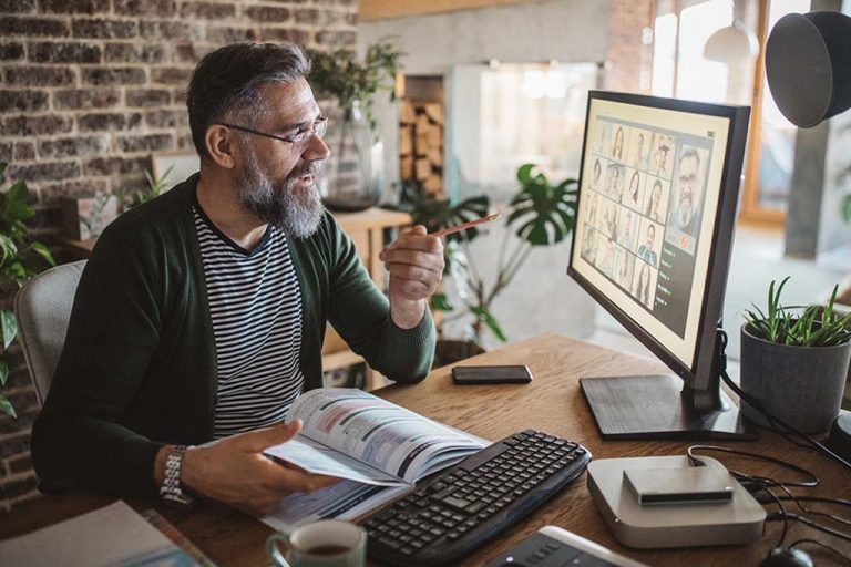 Great hearing benefits - Man at computer understanding hearing loss.