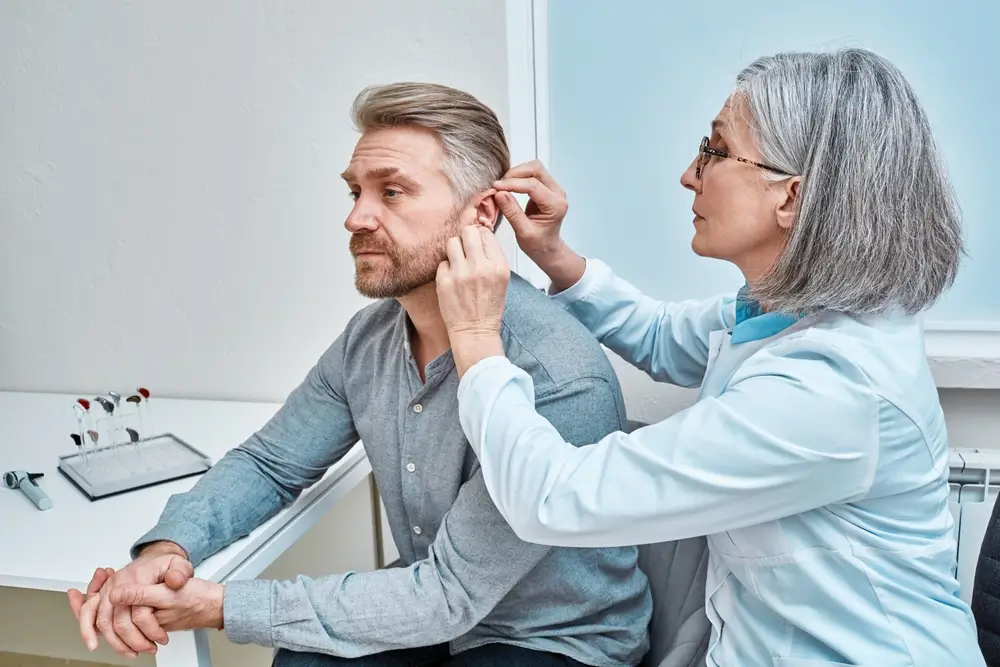 experienced doctor fitting hearing aid