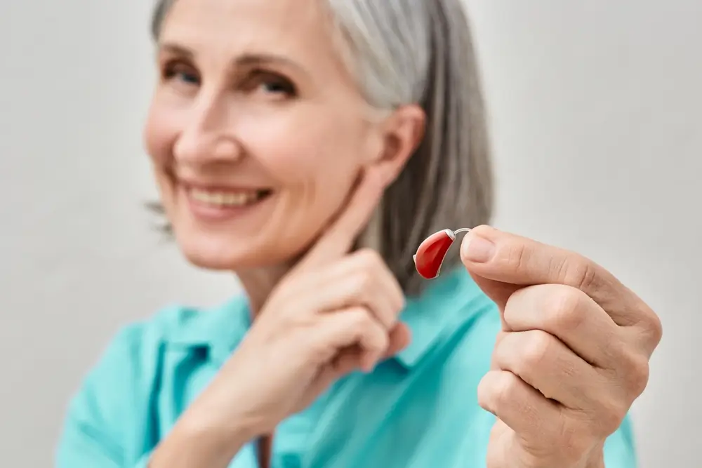 woman holding hearing aid